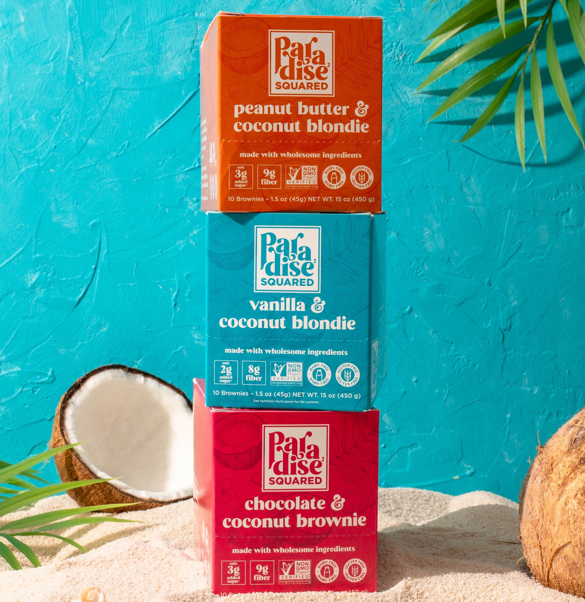 Brownie & Blondie 10-Pack Bundle. Paradise Squared boxes stacked on sand. Bright blue background with coconuts and palm fronds 